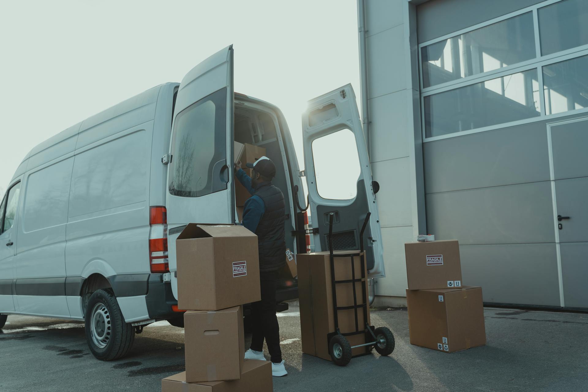 Delivery man unloading packages from a van, representing third-party logistics.